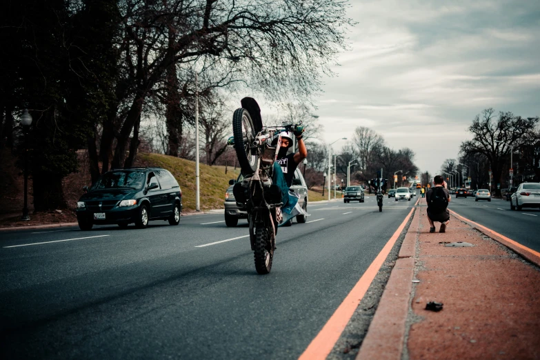 a bicyclist is being pulled down the street by a car