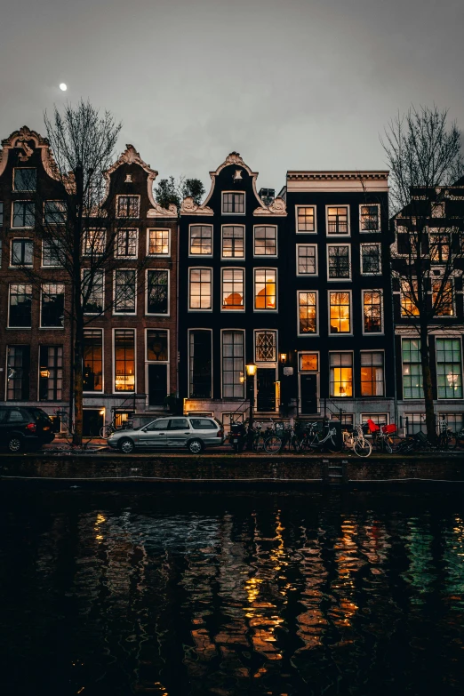 several dark, glowing windows reflecting on the water