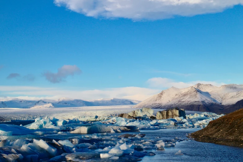 a large ice field with some mountains in the background