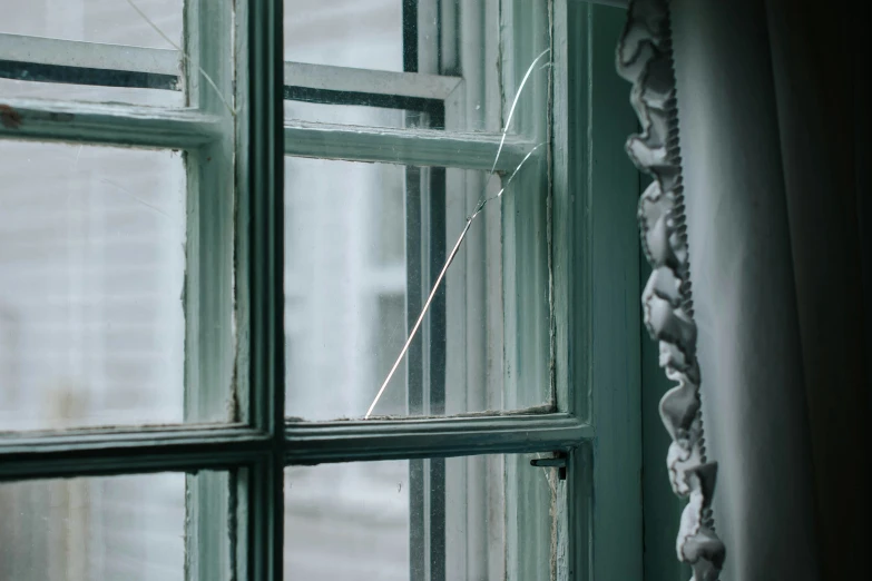 a window with broken glass near a small building