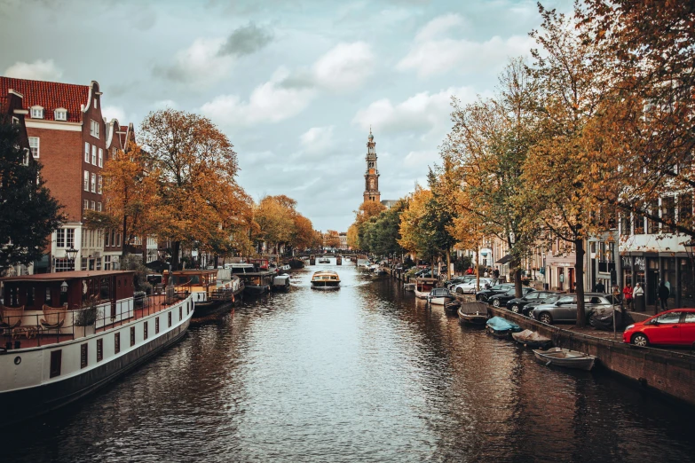 a narrow canal is lined with many boats on it