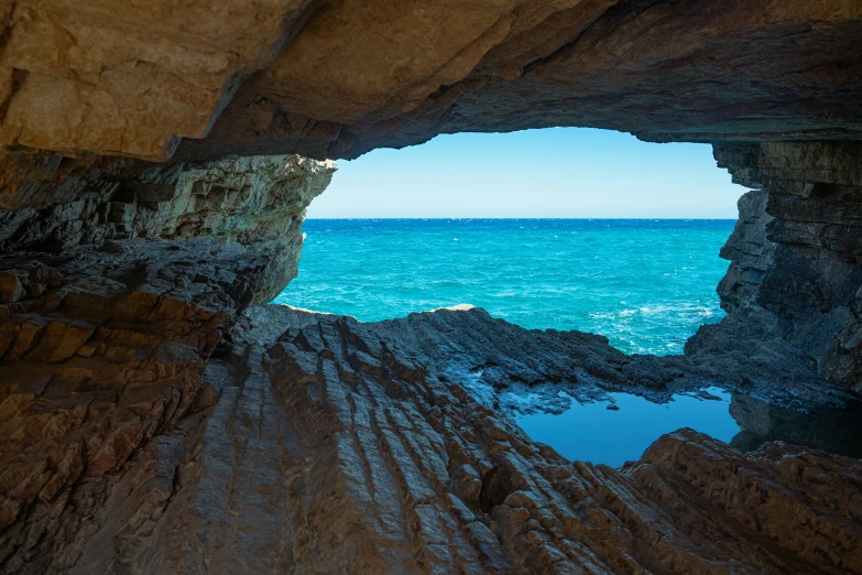 a close up of an arch with water and sky