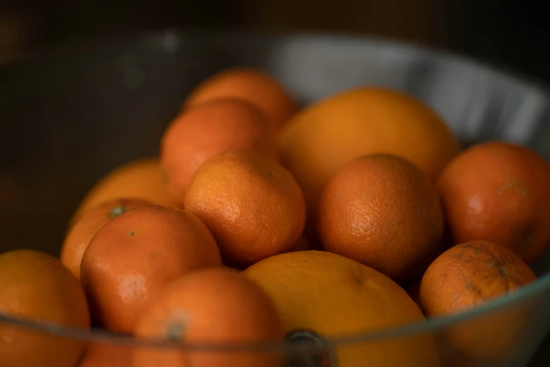 a bowl filled with oranges and two green peppers