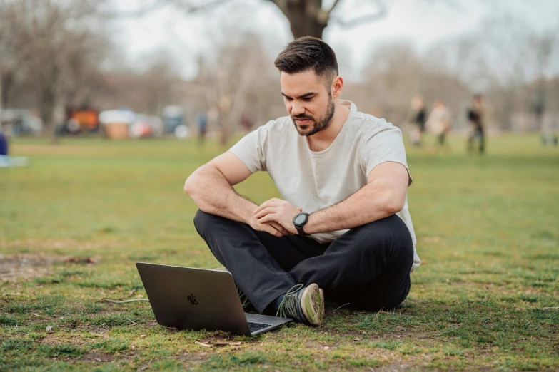 the man is on his laptop in the park