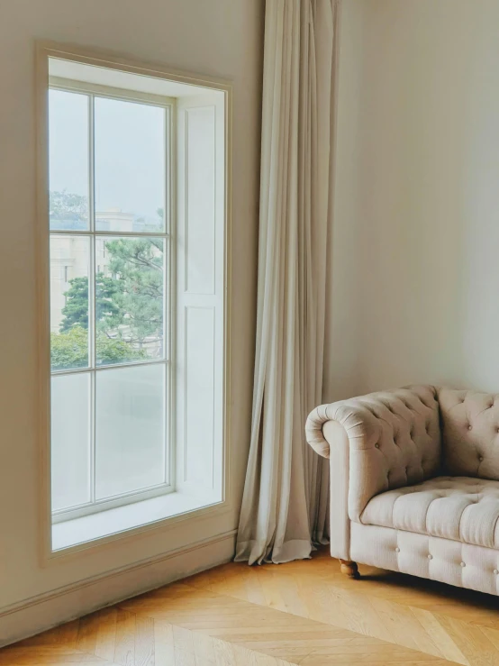 a white couch sitting in front of a large window