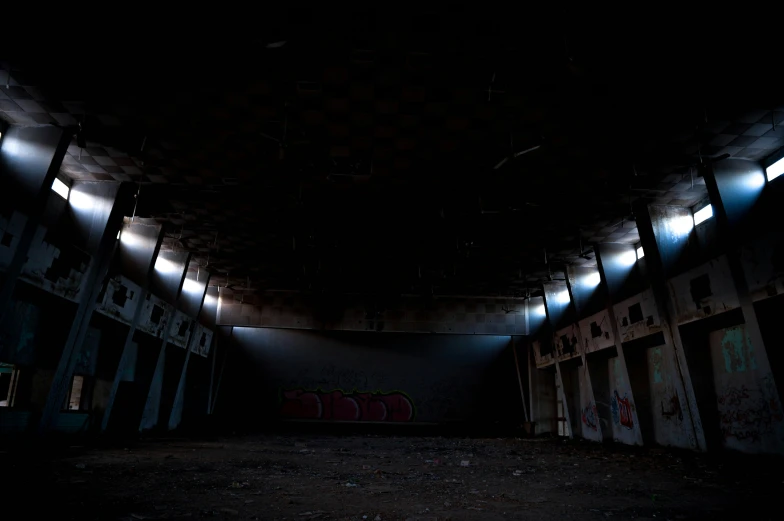 a dark room filled with stalls under lights