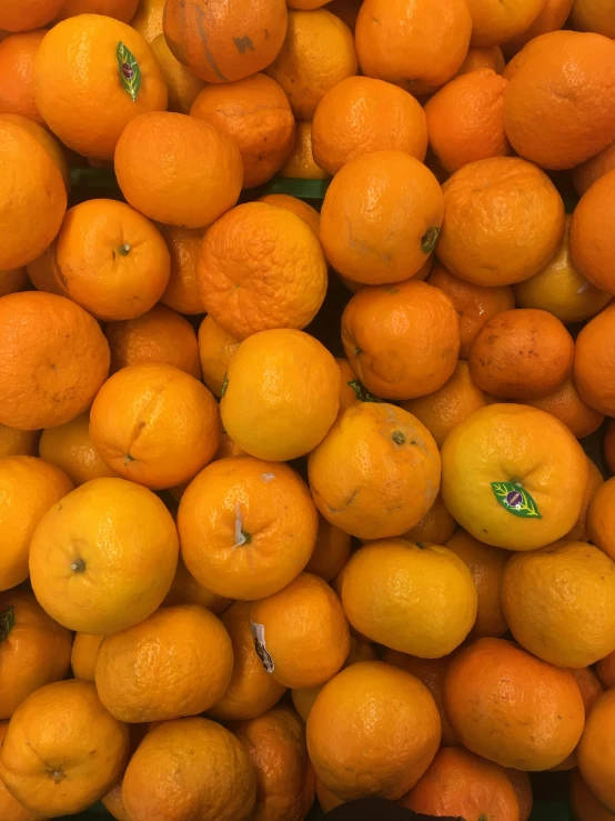 a pile of ripe oranges that are yellow