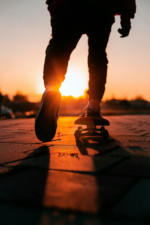 person skateboarding while sun setting in the background