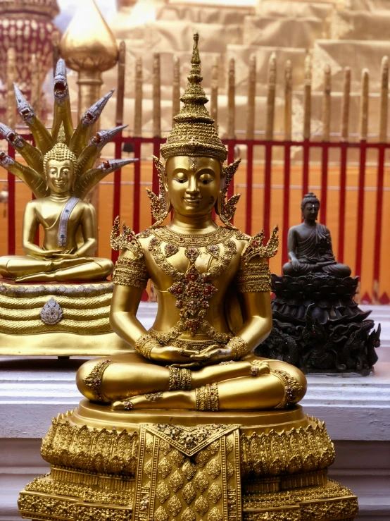 a golden buddha statue sitting in a row