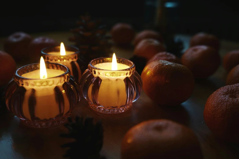 two small candles glowing while surrounded by apples