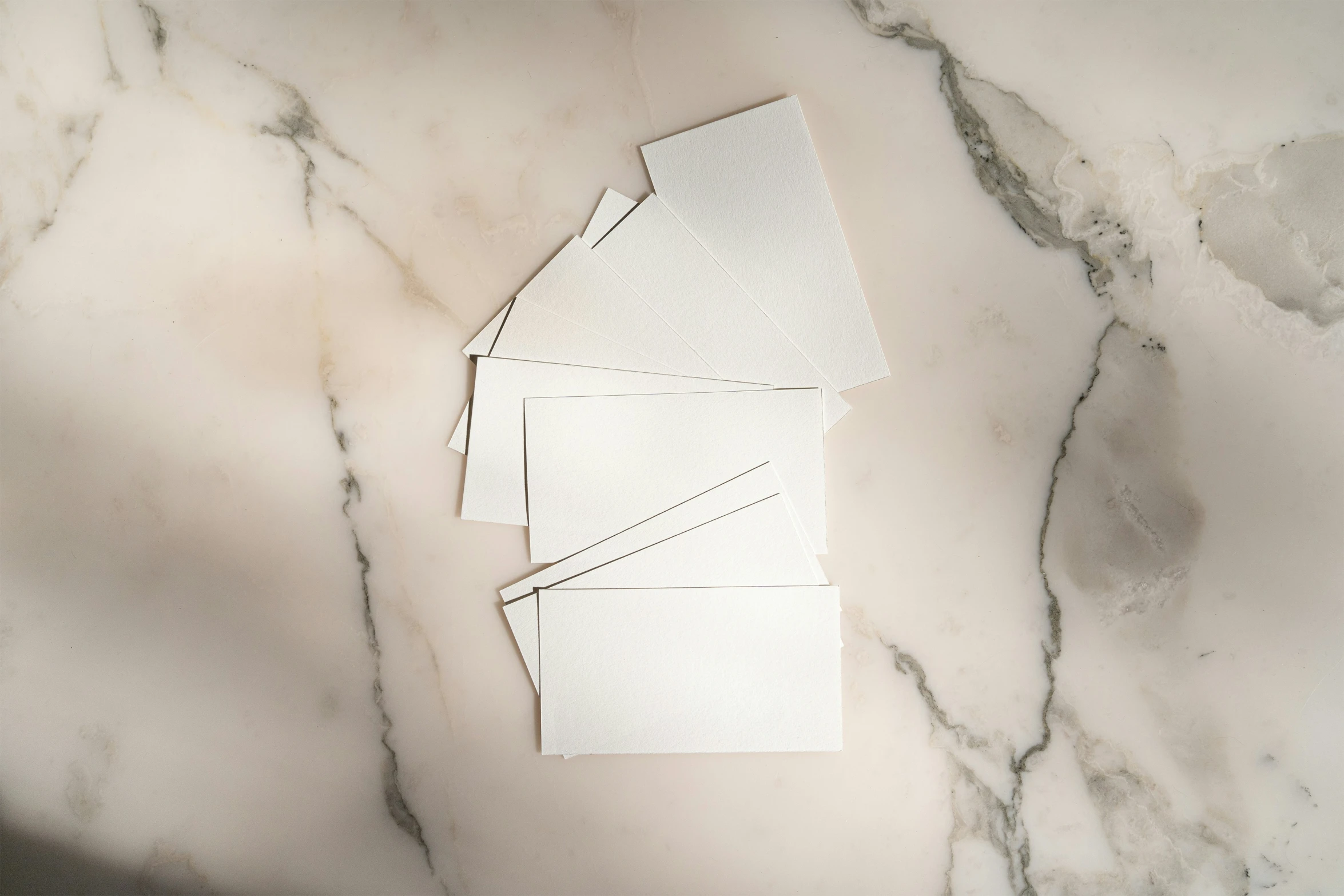 four pieces of cut paper placed on a marble surface