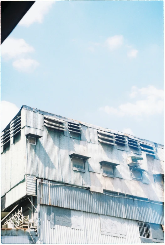 the side of an industrial building with the sky in the background