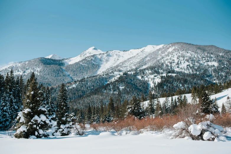 a person standing on a snow covered hill looking at the mountain