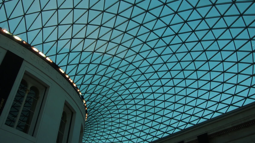 inside a very large, glass walled building with a blue sky