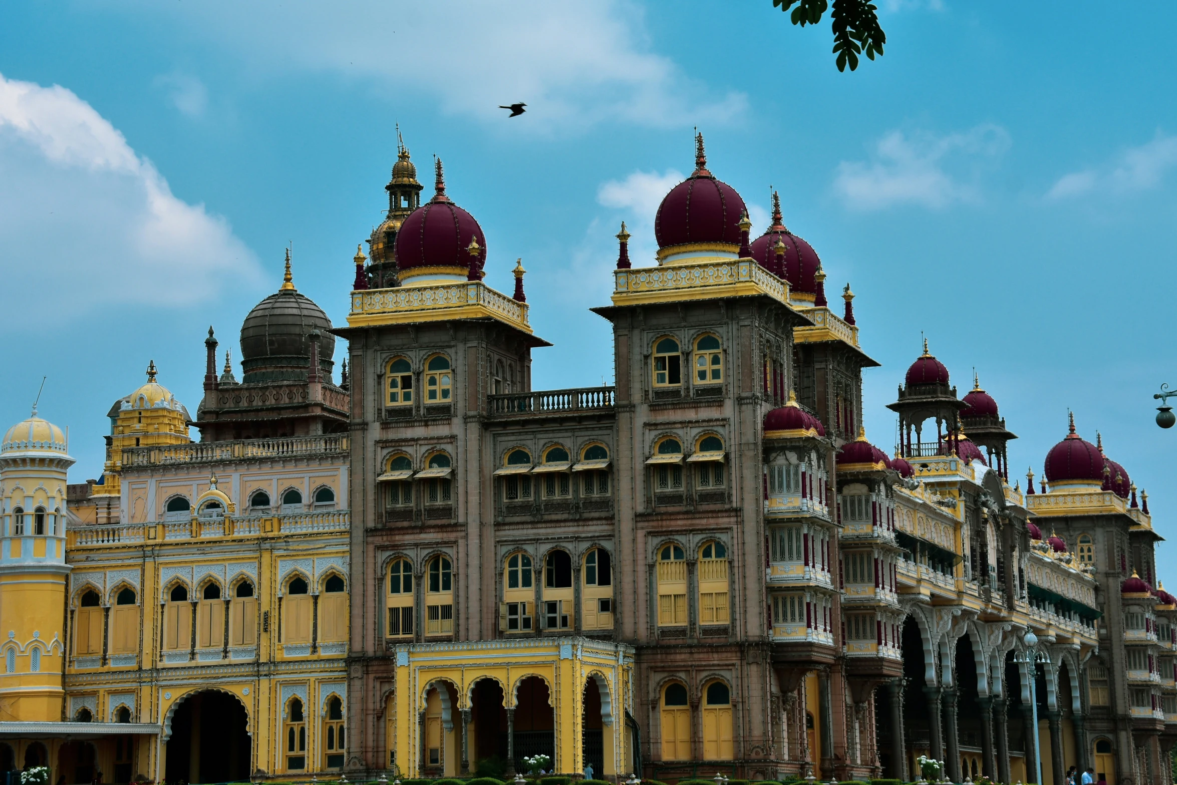 a castle with a red and gold roof, two clock faces and lots of gold domes