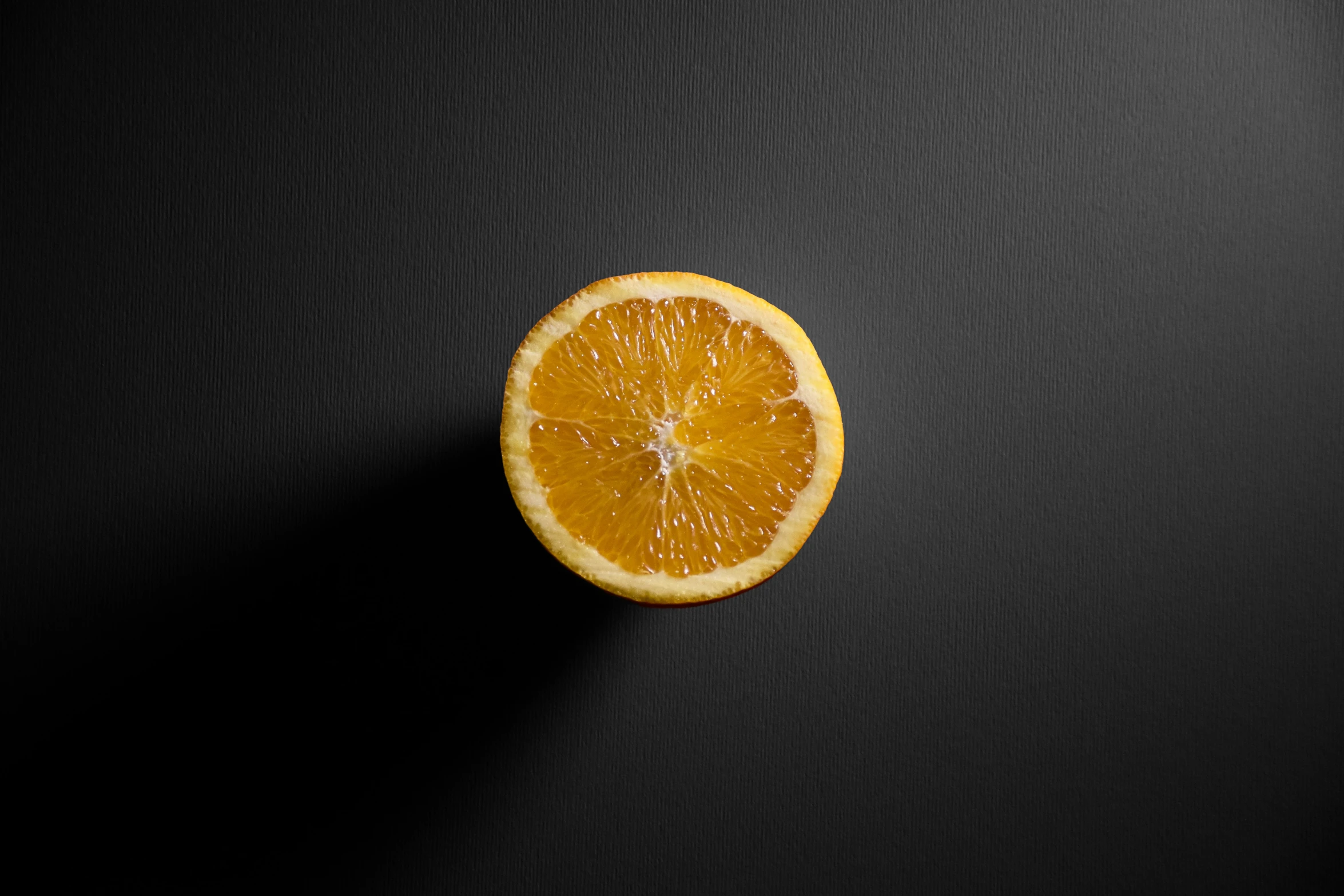 an orange is cut in half with a black background