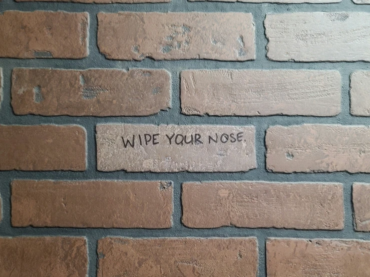 a brick wall with a message written on it