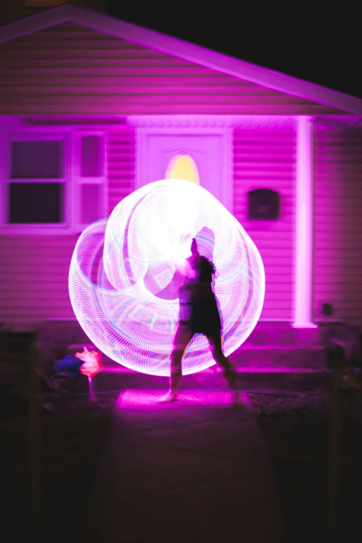 a person standing in front of a light up house
