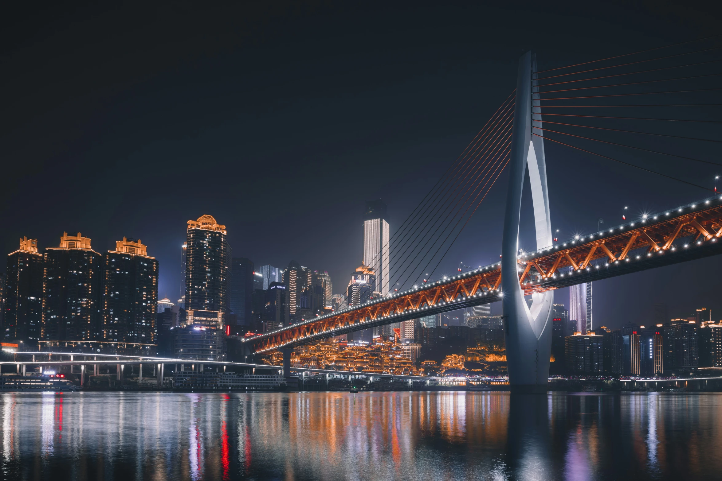 a very long bridge spanning across a city at night