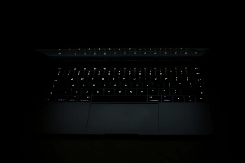 a dark po of a laptop keyboard on a table