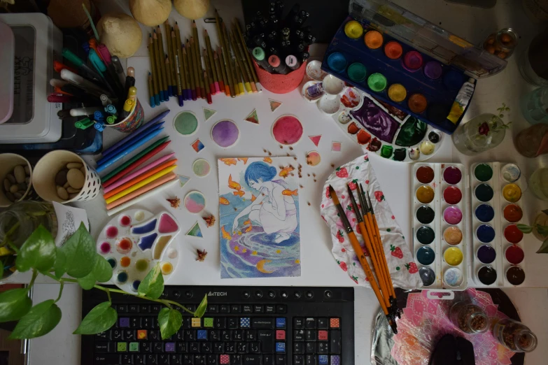 an overhead view of a desk with many types of art supplies