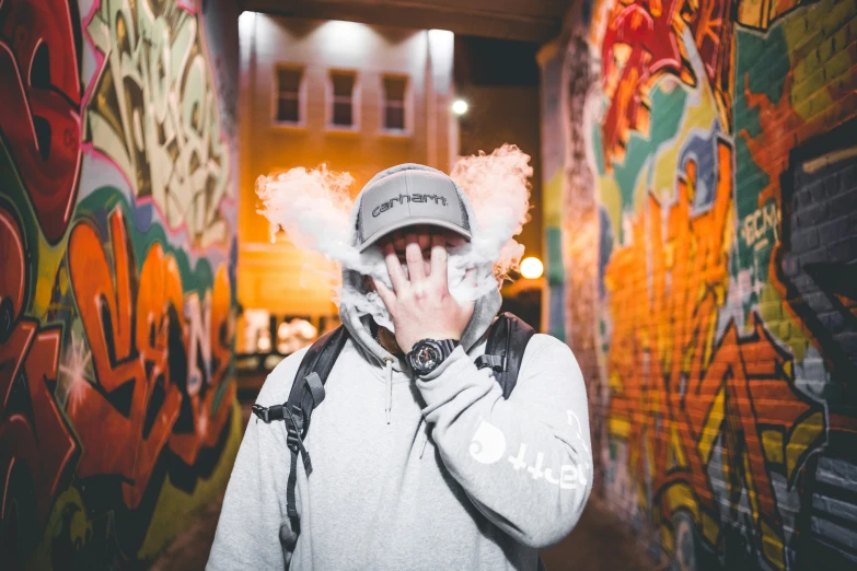 a young person standing in front of a wall with colorful graffiti