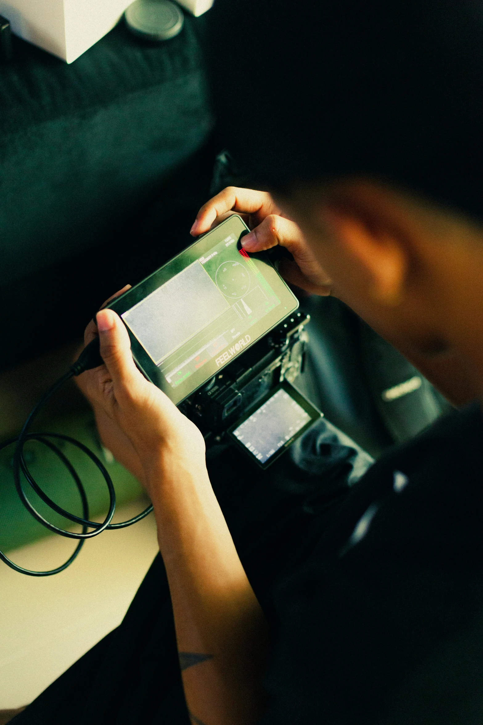 a person holding an mp3 player near a computer