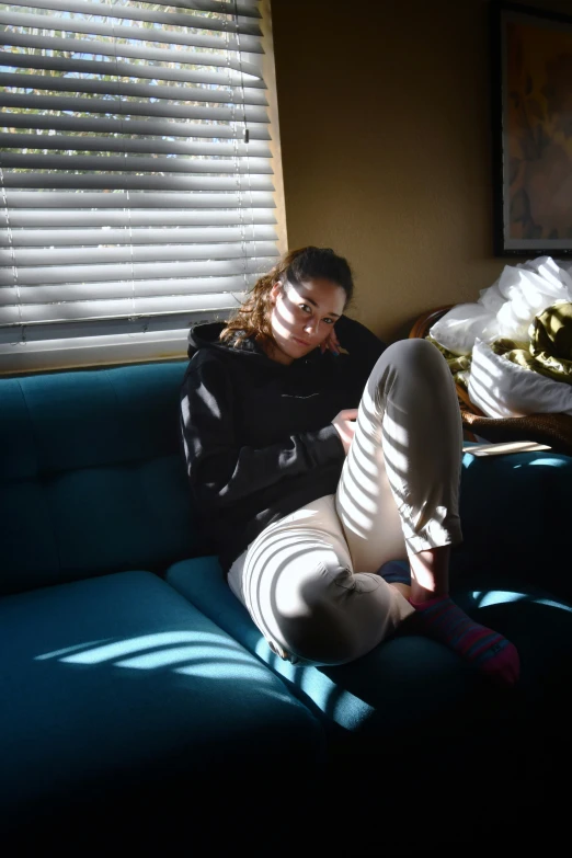 woman with her feet on the couch and her arm in the air