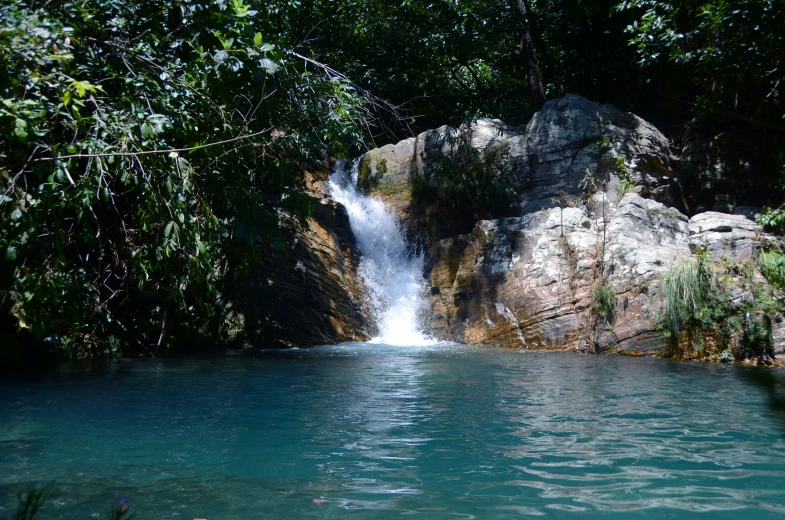 a body of water near a waterfall with rocks