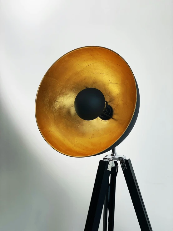 a large, golden object is on a tripod