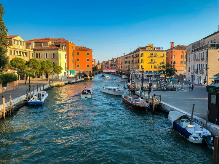 some boats are parked near the shore in a canal