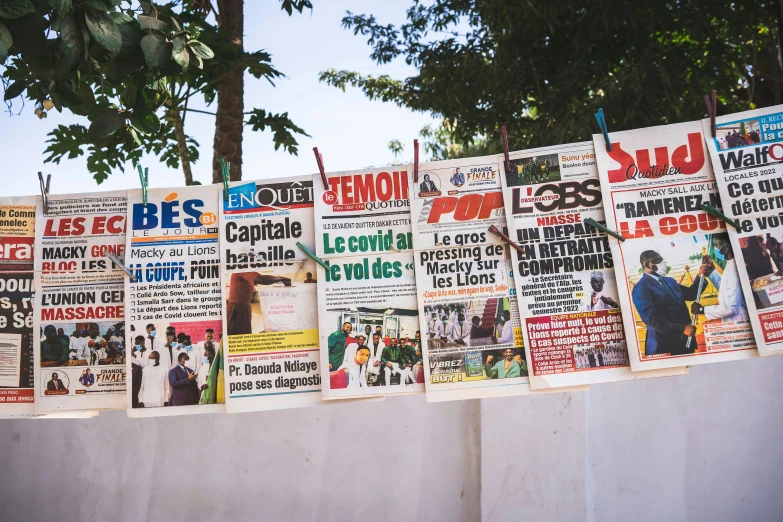 posters hang on a wall covered in newspapers