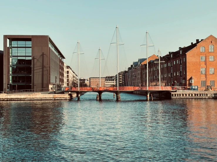 two buildings with sailboats docked on the shore in a city