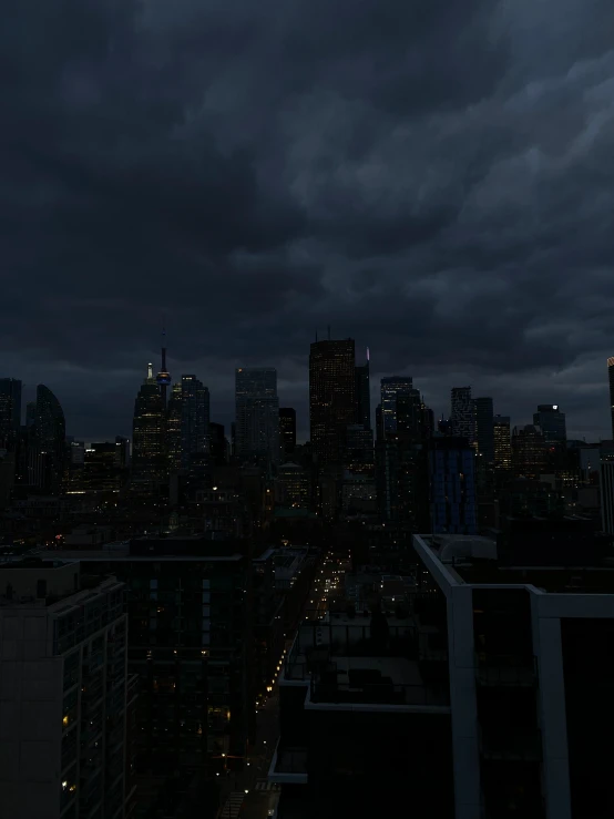 city buildings at night under dark sky with rain