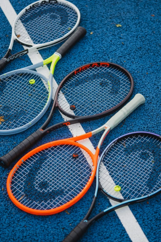 three tennis racquets that are laying next to each other