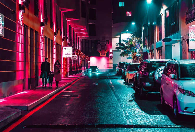 a line of parked cars sit along side a city street