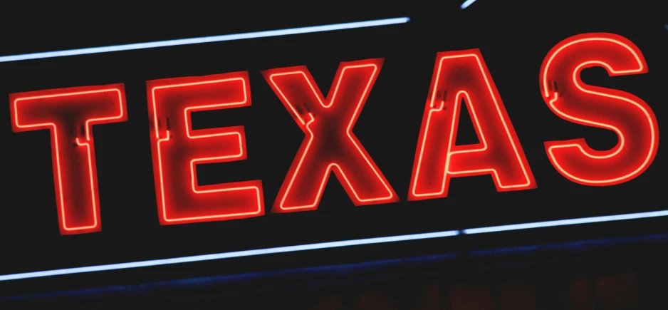 a sign lit up with the word texas in red