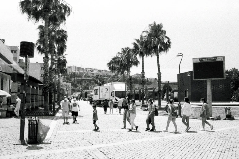 black and white pograph of people walking in the city