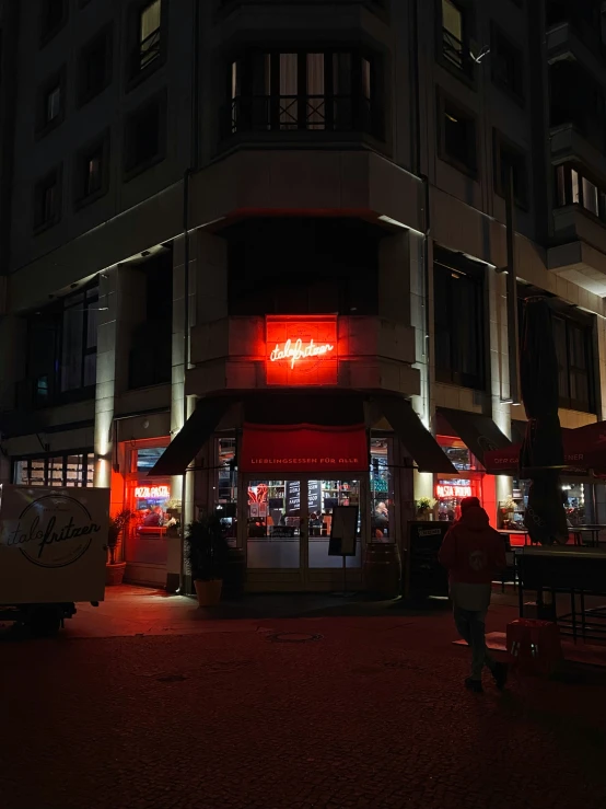 people standing on a sidewalk next to buildings at night