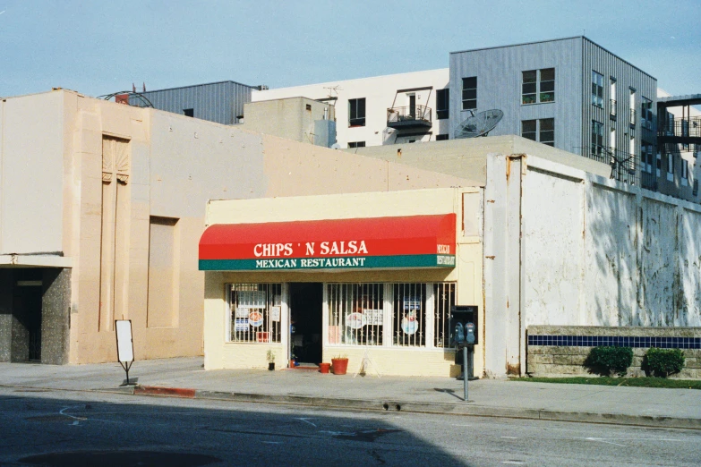 a vacant city street corner with a small restaurant and storage area