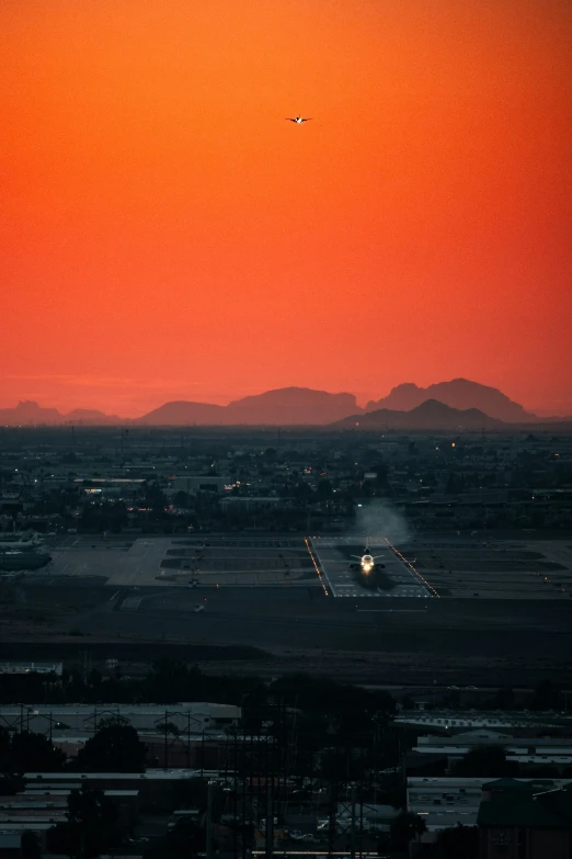 the sunrises over an airport as an airplane prepares to land