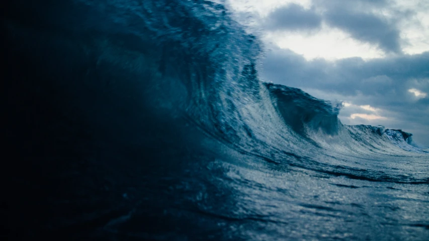 wave with gray sky and dark clouds in background