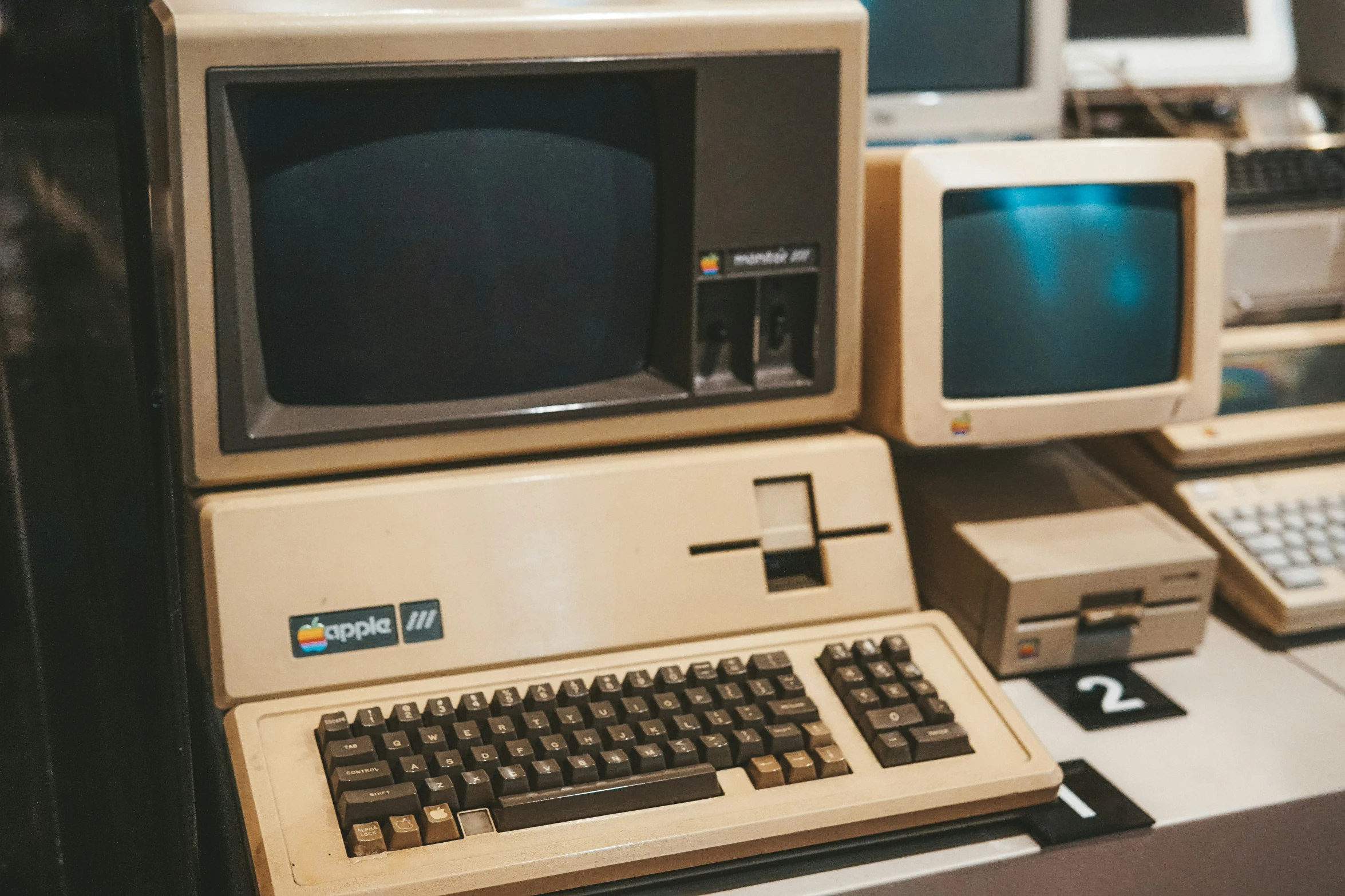 a row of computers sitting on top of a desk