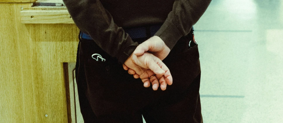 a man in black jacket holding hand over table