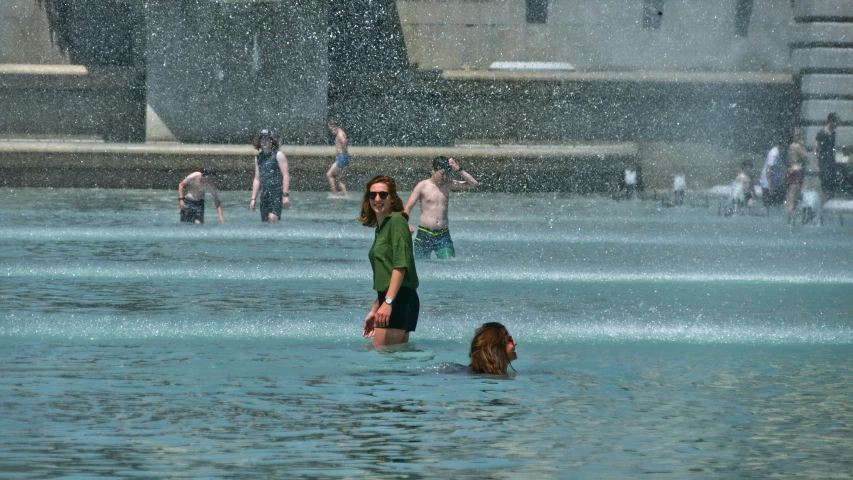 two people standing in water while they hold hands