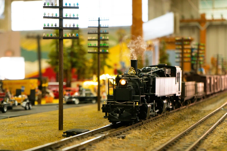 a model train traveling down tracks near a traffic light