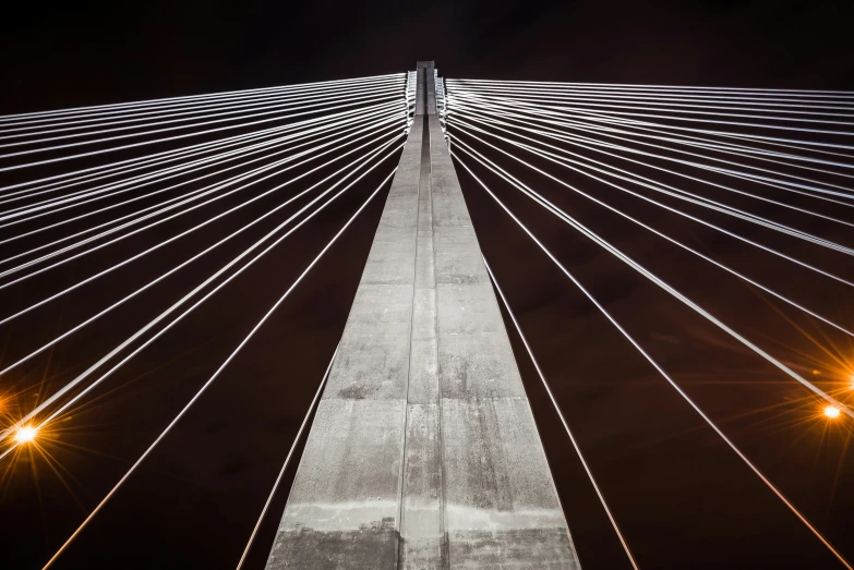 the view from below of a large bridge at night