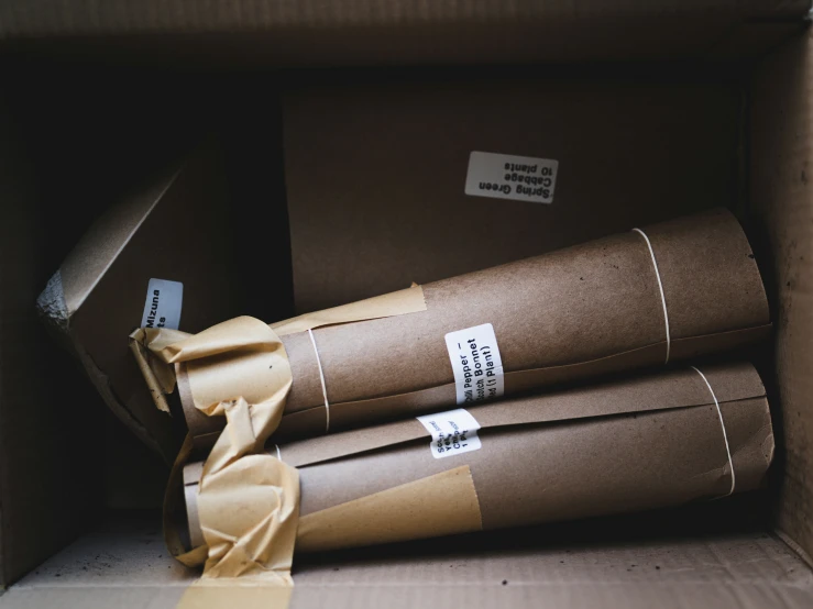 three packages in a box wrapped with brown paper