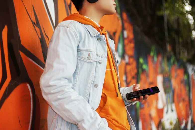 there is a man standing next to a wall holding a remote