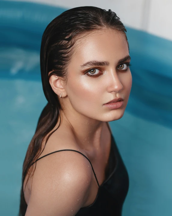 a woman stands in front of an indoor swimming pool